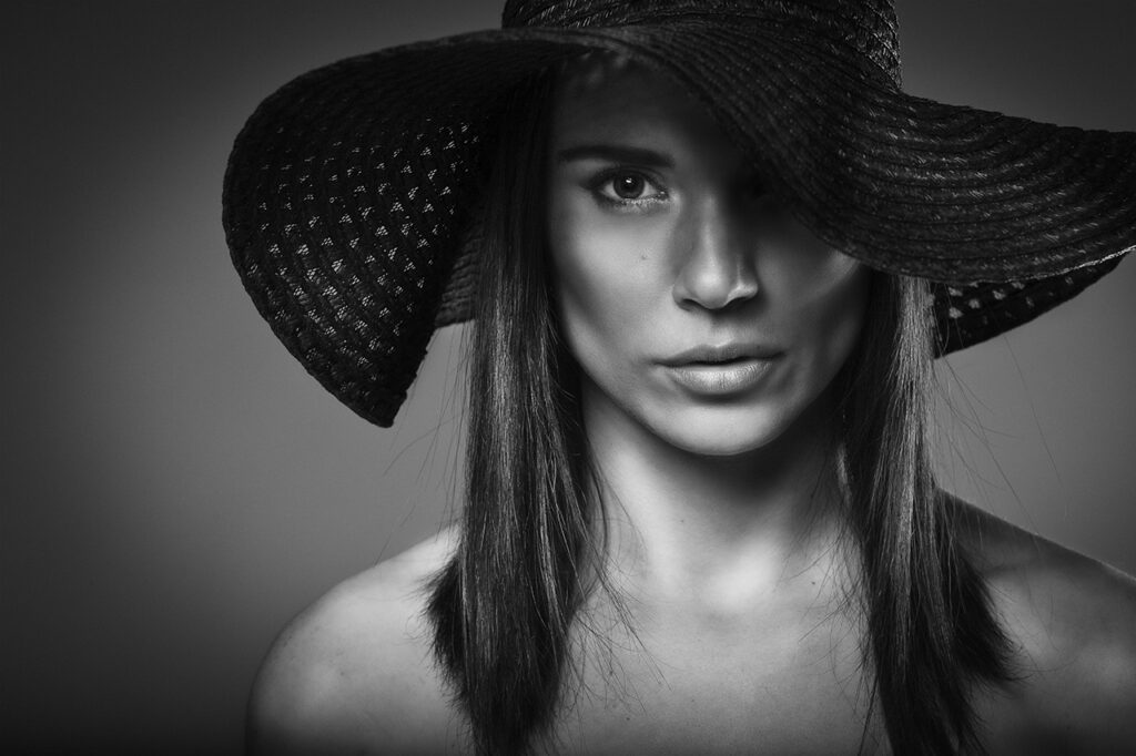 Femme photographiée en noir et blanc lors d'une expérience portrait signature en studio.