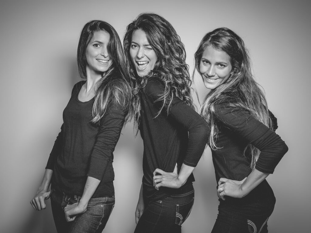 trois femmes souriantes photographiées en noir et blanc lors d'une expérience portrait en studio.