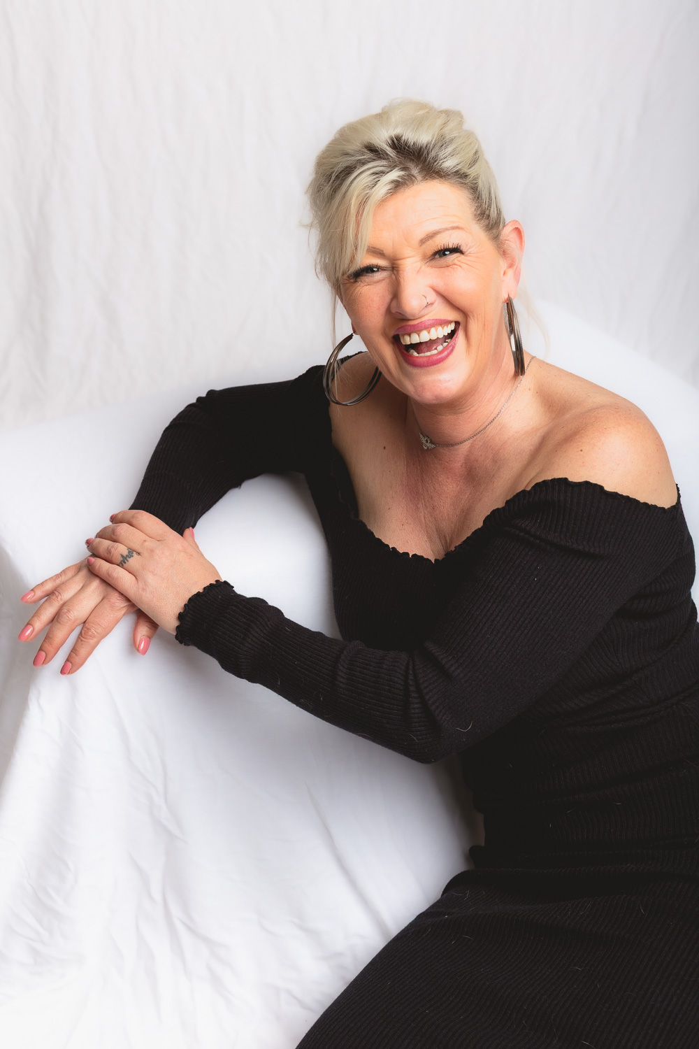 Femme souriante photographiée en couleur lors d'une expérience portrait en studio.